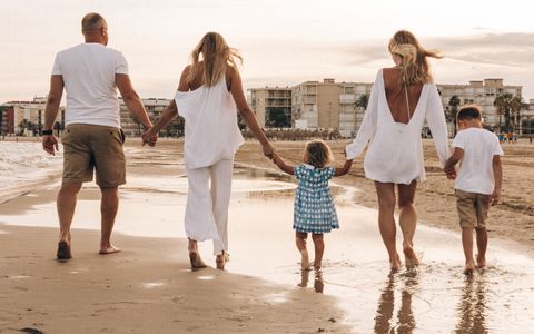 Family strolling on a sunny beach at Taniti Island